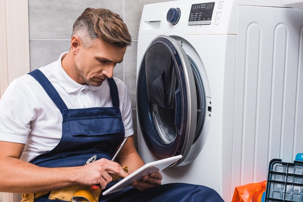 Appliance technician diagnosing a front-load washing machine in Winnipeg